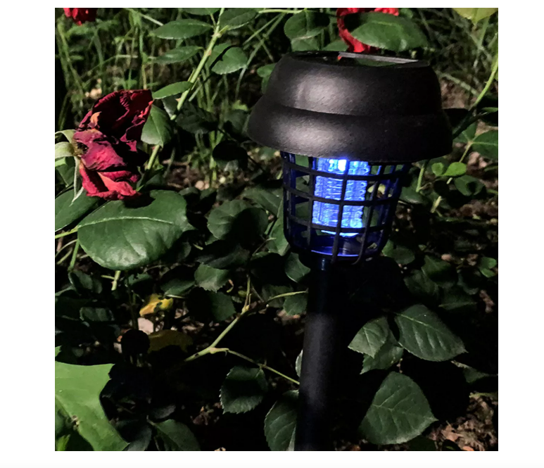 Lámpara solar repelente encendida de noche en jardín