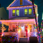 Casa con guirnaldas LED decorativas multicolor de noche, fotografía ambientacional referencial